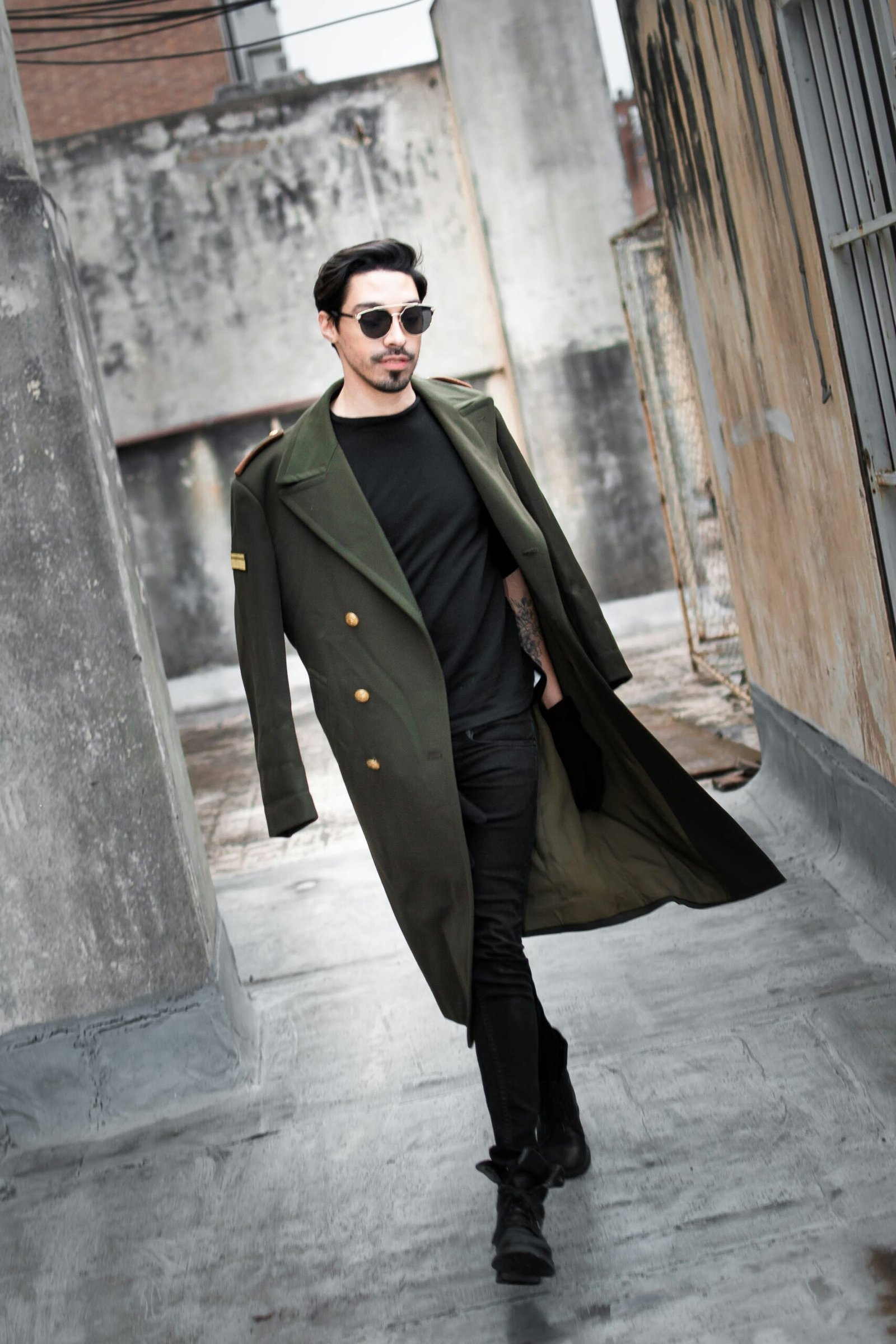 a man in a trench coat walking down a street